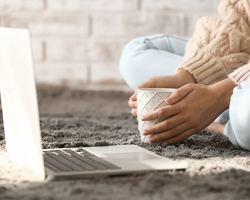 Woman sitting on floor with laptop for safer internet day