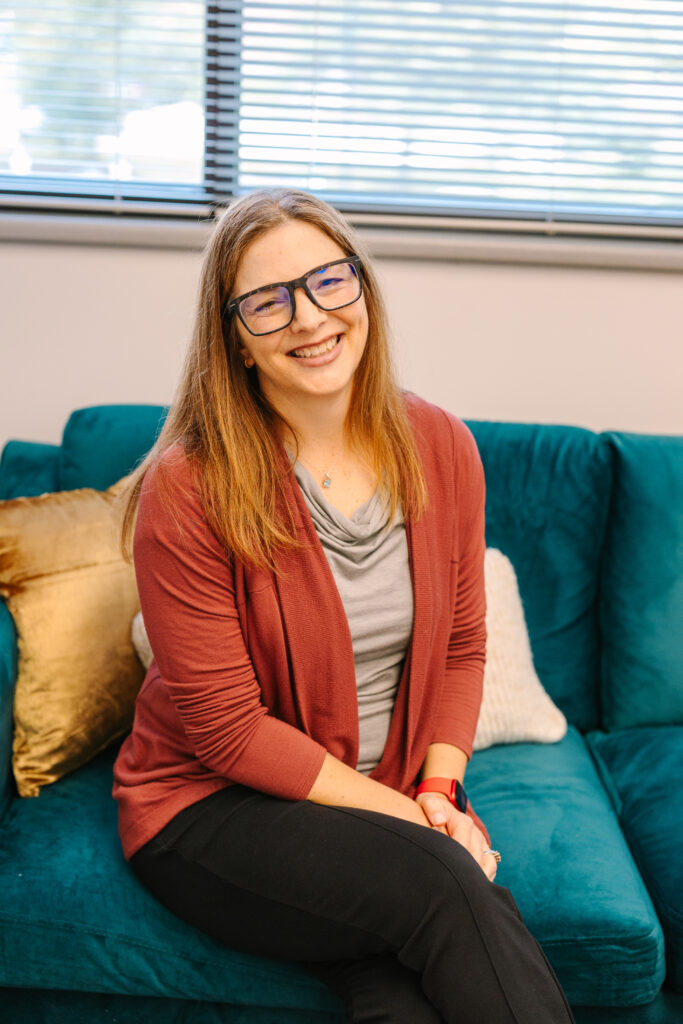 a therapist smiling on a green couch