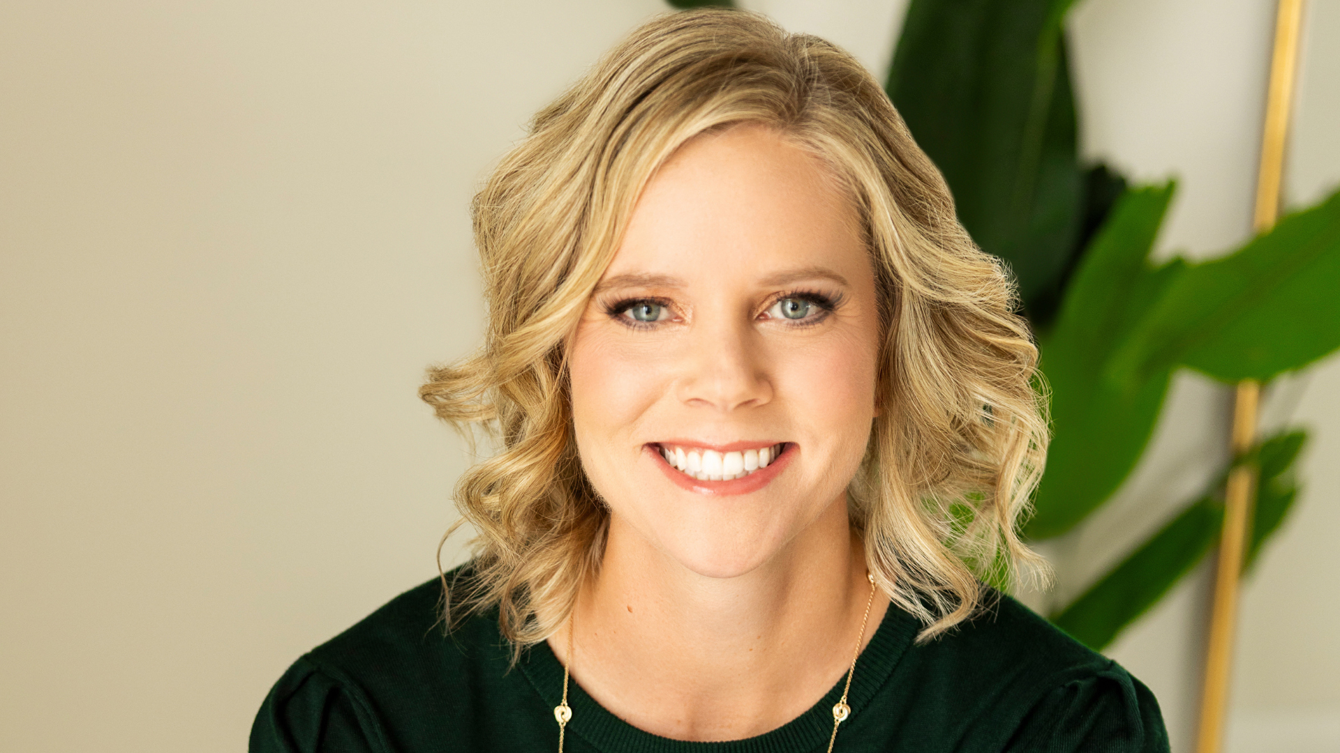 Portrait of Amy Racki, therapist in Madison WI, smiling in front of plants