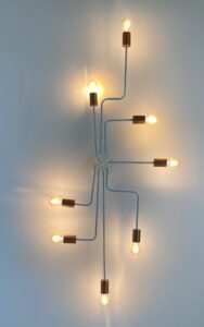 Branching light fixture with interconnected bulbs, symbolizing family systems, intergenerational patterns, and the insights gained through trauma-informed genogram therapy.
