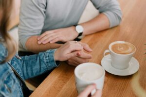 Couple holding hands during a conversation, representing compassionate support from Marriage and Family Therapists Madison WI.