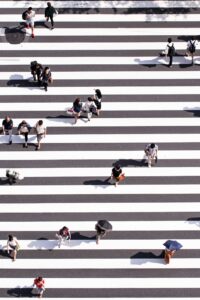 People crossing a crosswalk from different directions, representing the interconnected systems and relationships explored by Marriage and Family Therapists Madison WI.